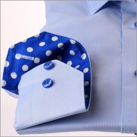 Chemise bleu clair à col et poignets à pois blancs sur fond bleu électrique