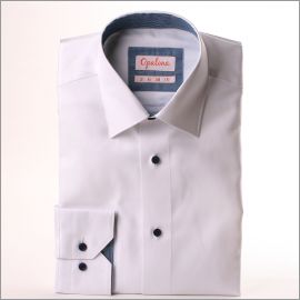 Camisa blanca con rayas azules delgadas sobre una tela azul marino en el cuello y los puños