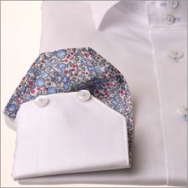 Camisa blanca con cuello y puños florales azules.