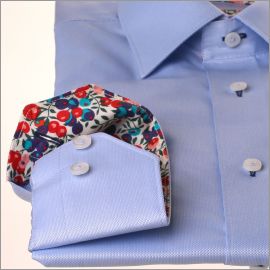 Camisa azul con cuello y puños florales en rojo, rosa y violeta